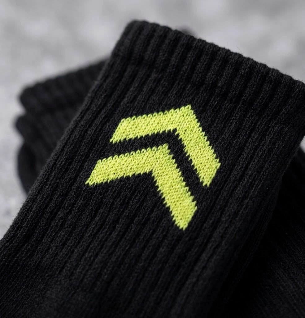 Gros plan des Chaussettes Galon : galon lime tricoté en jacquard dans la côte noire.